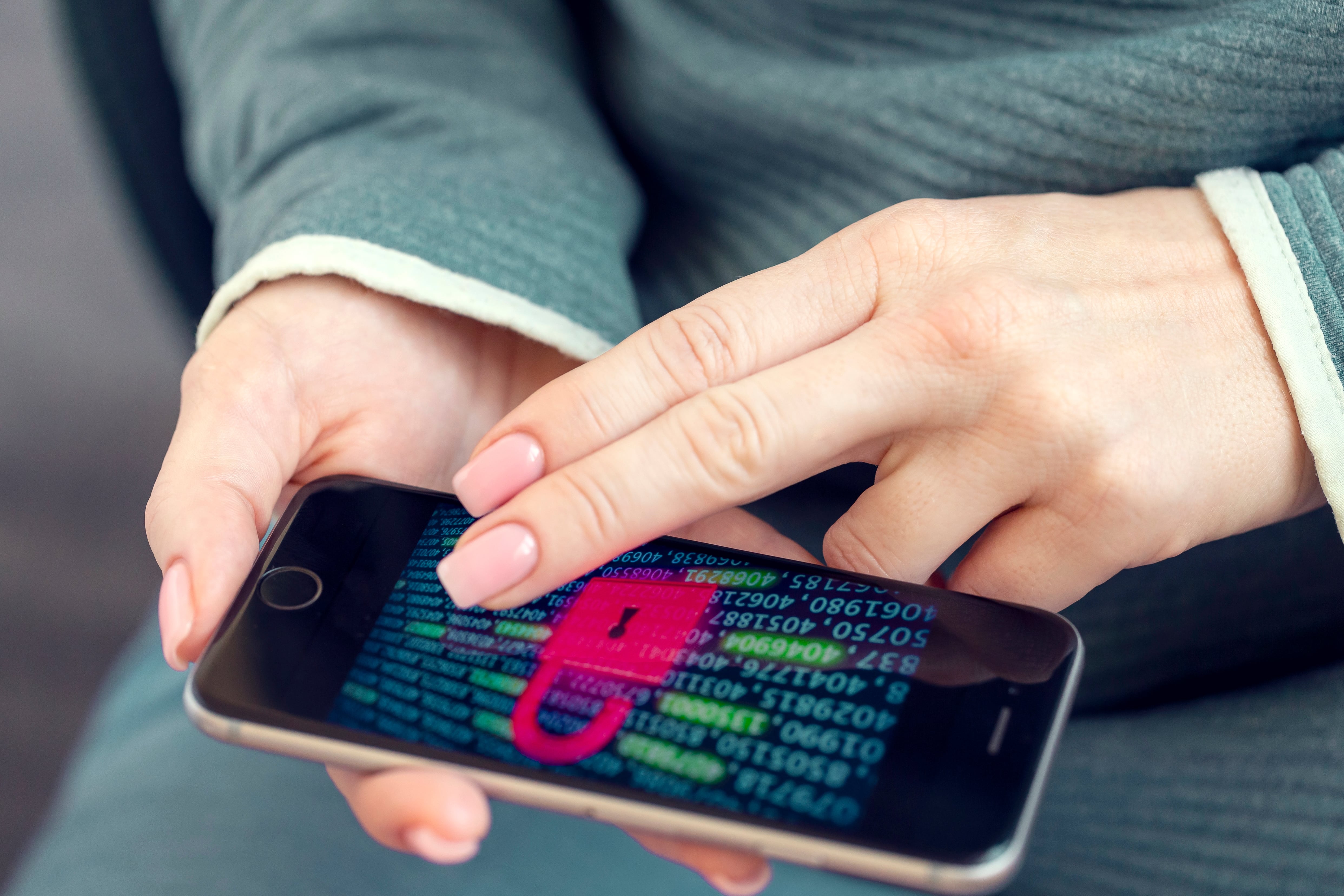 Hands hold a cell phone with a large lock showing on screen.