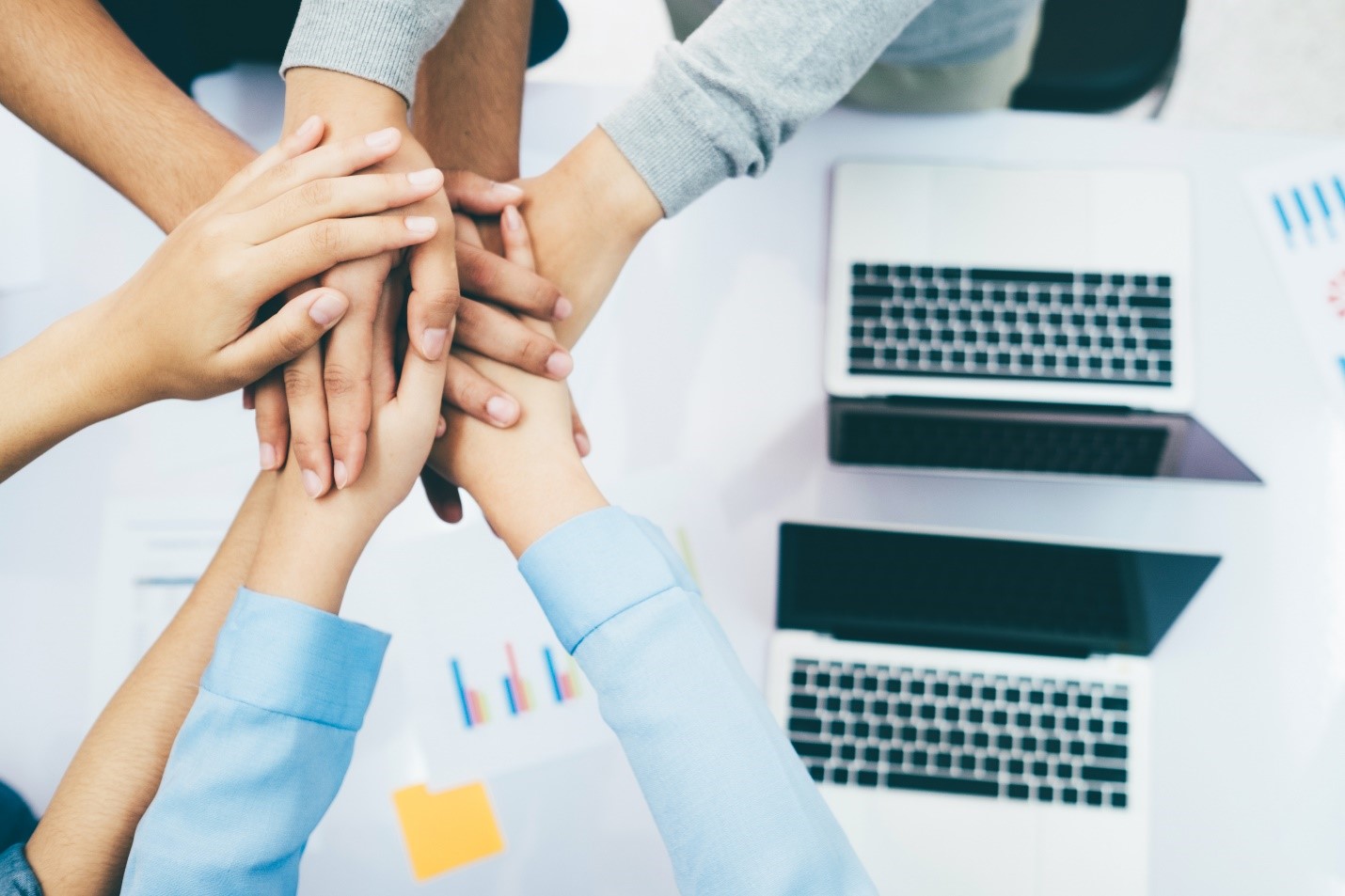 Close-up of various people’s hands stacked to signify unity